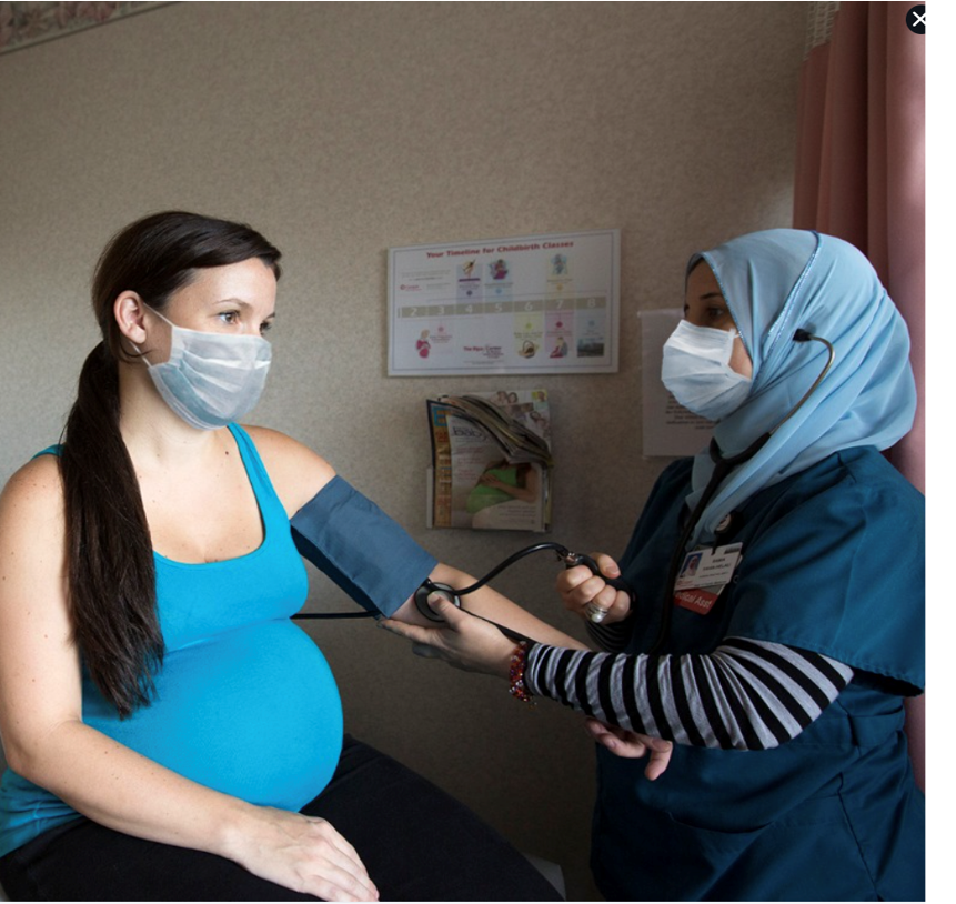 nurse checking blood pressure on pregnant women