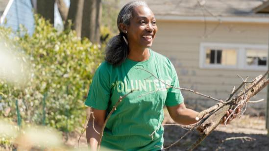 volunteer picking up tree branches