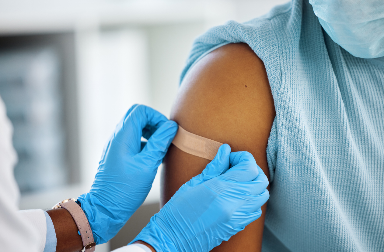 healthcare working putting a bandaid on a child's arm