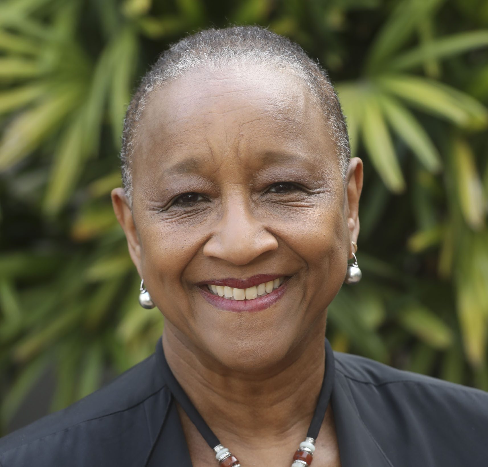 portrait of women with short hair and wearing earrings and neckless