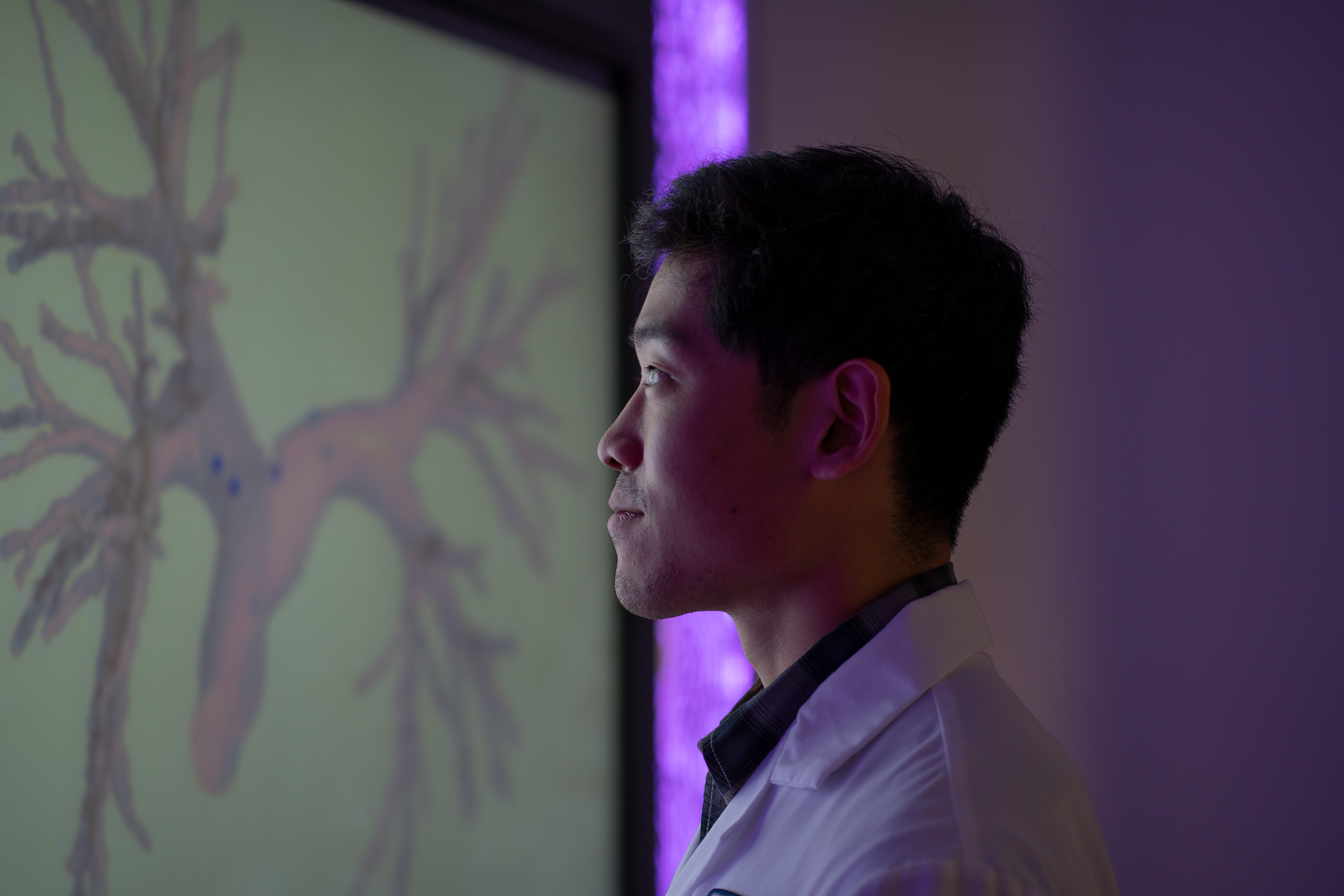 person on white coat looking at the screen