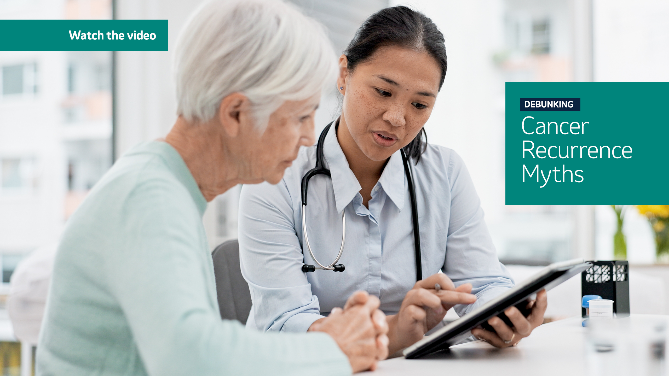 photo of a doctor holding clipboard and pointing something out to the woman sitting next to her