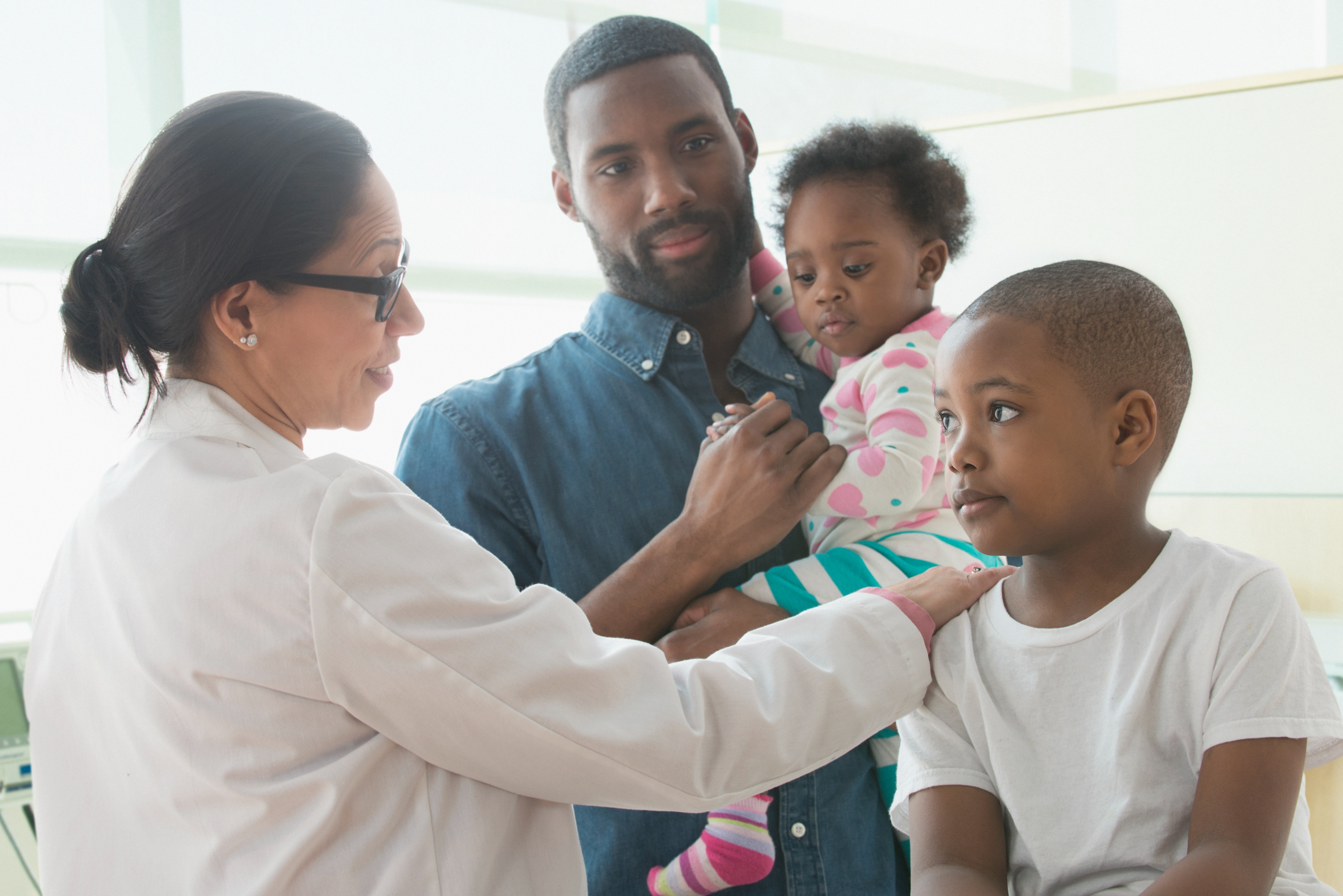 family being consulted by doctor wearing white coat