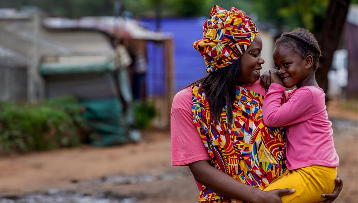 Mother holding a a baby and they're smiling at each other