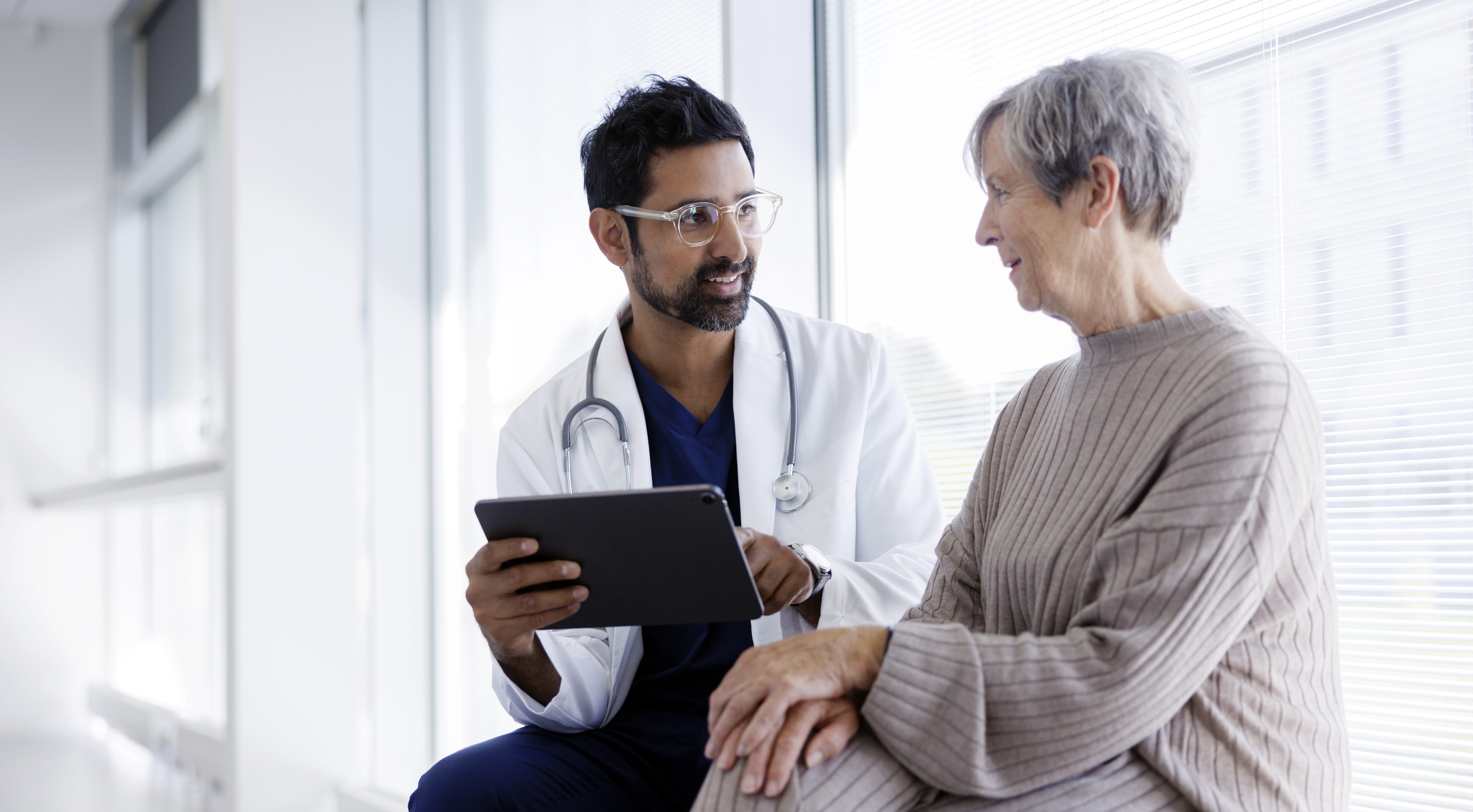 older woman sitting and talking with doctor